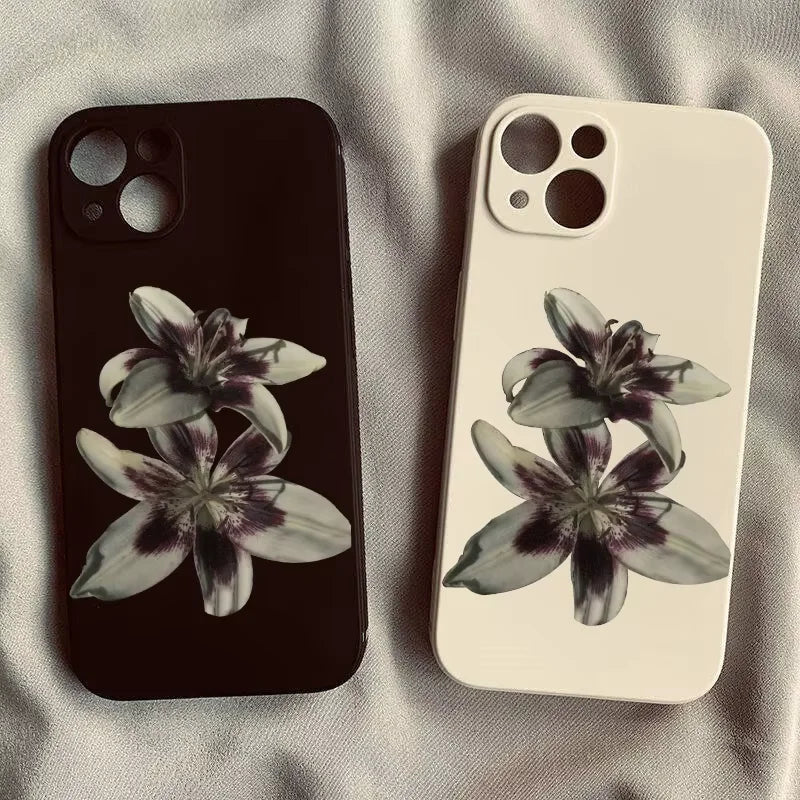 Deux coques iPhone à motifs de lys sur un tissu clair