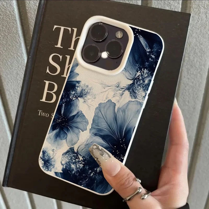 Coque iPhone à grandes fleurs bleues sur fond clair, tenue en main